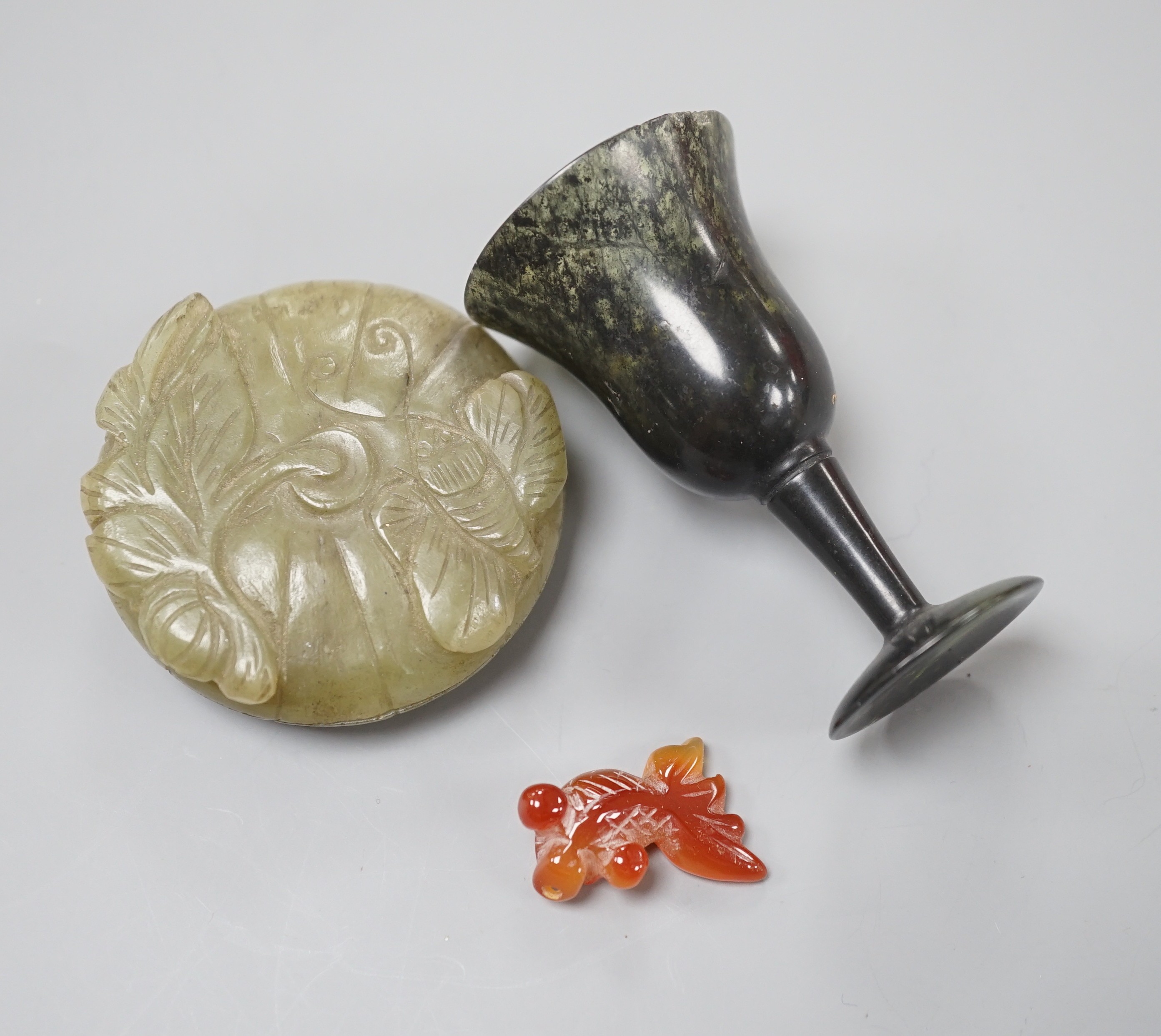 A Chinese green jade ‘butterfly’ box and cover, a moss agate cup, cup and an agate fish, largest 7cms high.